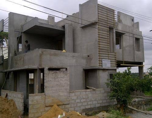 Small house nearing completion with worker on the terrace